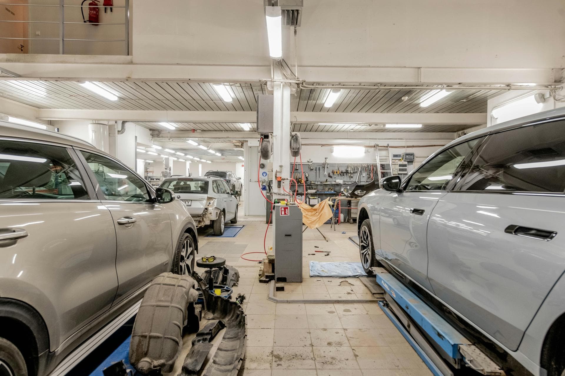 Atelier de garage spacieux avec des véhicules en réparation sur les postes de travail