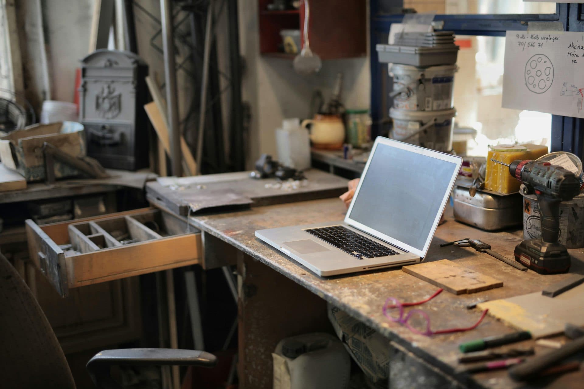 Ordinateur portable posé sur l'établi d'un petit atelier