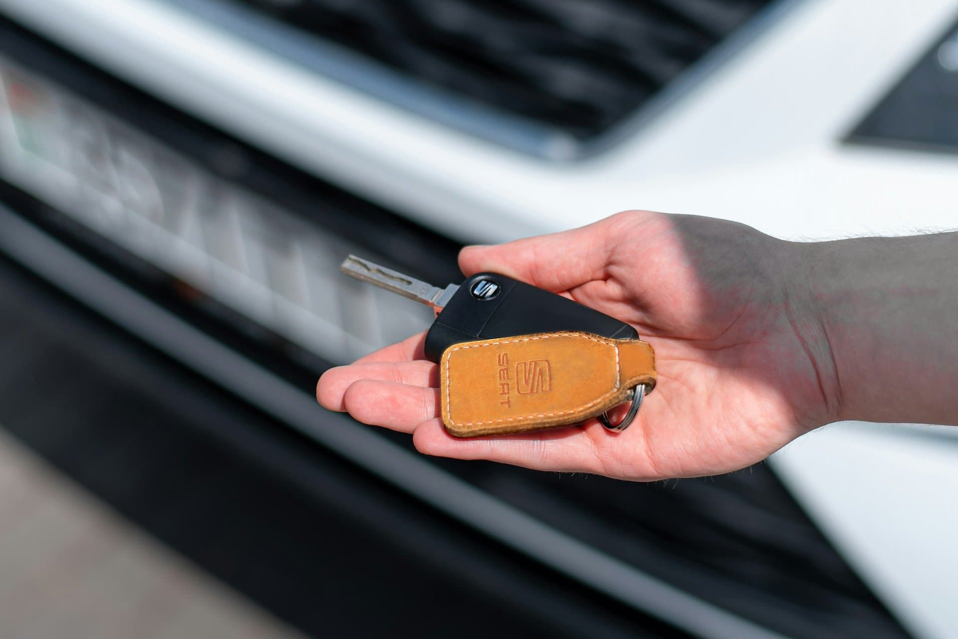 Remise des clés d'un véhicule de prêt au client, devant la voiture