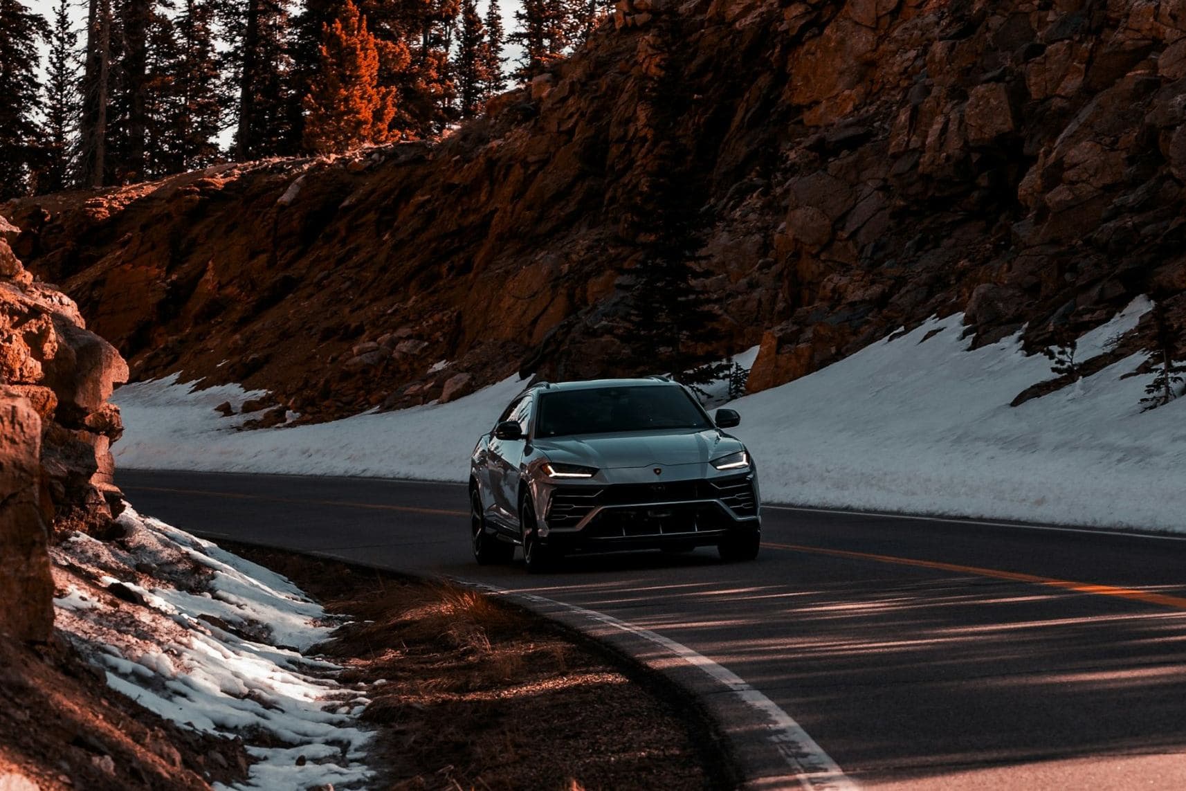 SUV sur une route de montagne bordée de neige, en zone soumise à la loi Montagne